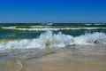 Sea waves wash the beach against a blue sky. Landscape on a wild beach. The sea in the summer Royalty Free Stock Photo