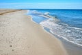 Sea waves washed clean beach made of shells. Landscape on a wild beach.