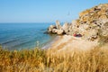 Sea wild cove in the rocks with three tents. Sand beach Royalty Free Stock Photo