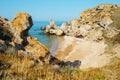 Sea wild cove in the rocks with three tents. Sand beach