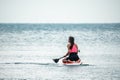 Sea woman and man on sup. Silhouette of happy young woman and man, surfing on SUP board, confident paddling through