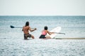 Sea woman and man on sup. Silhouette of happy young woman and man, surfing on SUP board, confident paddling through Royalty Free Stock Photo