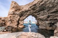 Sea woman rocks grotto. A woman in a blue jacket stands on a rock above a cliff above the sea and looks at the raging Royalty Free Stock Photo