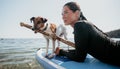 Sea woman sup. Silhouette of happy positive young woman with her dog, surfing on SUP board through calm water surface Royalty Free Stock Photo