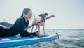 Sea woman sup. Silhouette of happy positive young woman with her dog, surfing on SUP board through calm water surface Royalty Free Stock Photo