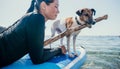 Sea woman sup. Silhouette of happy positive young woman with her dog, surfing on SUP board through calm water surface Royalty Free Stock Photo