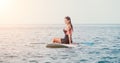 Sea woman sup. Silhouette of happy young woman in pink bikini, surfing on SUP board, confident paddling through water Royalty Free Stock Photo