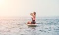 Sea woman sup. Silhouette of happy young woman in pink bikini, surfing on SUP board, confident paddling through water Royalty Free Stock Photo