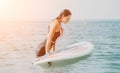 Sea woman sup. Silhouette of happy young woman in pink bikini, surfing on SUP board, confident paddling through water Royalty Free Stock Photo