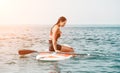 Sea woman sup. Silhouette of happy young woman in pink bikini, surfing on SUP board, confident paddling through water Royalty Free Stock Photo