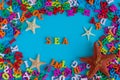 Sea - word composed of small colored letters. Summer vacation souvenir - starfish from tropical sandy ocean beach Royalty Free Stock Photo