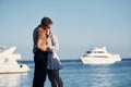 Sea and yacht at background. Happy young couple is together on their vacation. Outdoors at sunny daytime
