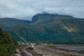 Sea yacht lying on the shore on the background a high cloud-covered mountai Royalty Free Stock Photo