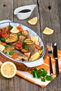 Seabass fish baked with vegetables, herbs and lemon