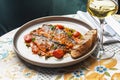 Seabass Neapolitan style with tomatoes and capers, copy space. food concept