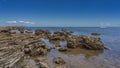 The seabed was exposed at low tide. Picturesque rocks with a layered structure rise Royalty Free Stock Photo