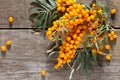 Seabuckthorn berries branch on vintage wooden background. Top view, place for your text