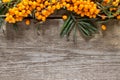 Seabuckthorn berries branch on vintage wooden background.