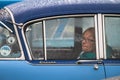 Older woman looks out from the inside of a classic Cresta car window through the rain