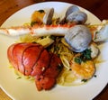 Seafood dinner plate of spaghetti, lobster tail, clams, shrimp, scallops, and crab leg Royalty Free Stock Photo