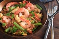 Seafood dish with prawns, rice, chicken meat and vegetables in a paella pan on a dark rustic wooden table, selected focus Royalty Free Stock Photo