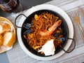 Seafood fideua with shrimps and clams served in paellera with allioli Royalty Free Stock Photo