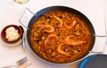 Seafood fideua with shrimps, squid and clams in paellera with allioli Royalty Free Stock Photo