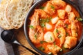 Seafood and fish stew such as shrimp, mussels, scallops, squid with tomatoes close-up in a bowl. Horizontal top view