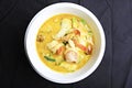 Seafood green curry in a white bowl