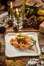 Seafood Green Salad with Salmon, Avocado and Shrimps on white plate on christmas decorated background