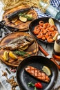 Seafood, grilled dorado fish, grilled salmon steak, smoked mackerel fish and fried shrimps with lemon and rosemary on wooden Royalty Free Stock Photo