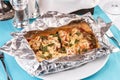 Fish baked in a foil with tomatoes, entirely with onion rings, red and green peppers, chili peppers, greens, cheese, mushrooms Royalty Free Stock Photo