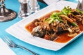 Fish stewed in tomato sauce with onion rings, mushrooms, herbs and vegetables. Caucasian national cuisine Royalty Free Stock Photo