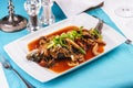 Fish stewed in tomato sauce with onion rings, mushrooms, herbs and vegetables. Caucasian national cuisine Royalty Free Stock Photo