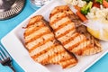 Grilled seafood. Salmon fish steak with greens, broccoli, cauliflower, carrots, cucumber, lemon and chili. Royalty Free Stock Photo