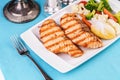 Grilled seafood. Salmon fish steak with greens, broccoli, cauliflower, carrots, cucumber, lemon and chili. Royalty Free Stock Photo