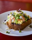 Seafood morning breakfast sandwich with shrimps, egg omlette, and loots of fresh greenery on top.