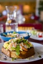 Seafood morning breakfast sandwich with shrimps, egg omlette, and loots of fresh greenery on top.