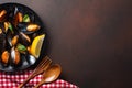 Seafood mussels and basil leaves in a black plate with towel, bread slices, wooden spoon and fork on rusty background Royalty Free Stock Photo