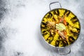 Seafood paella in the fry pan with prawns, shrimps, octopus and mussels. White background. Top view. Copy space