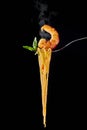 Seafood pasta with shrimp and mint leaf at fork. spanish and italian cuisine concept at black backdrop. Copy space Royalty Free Stock Photo