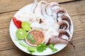 Seafood plate squid food on white plate, Fresh squid cooked boiled steam with vegetable salad lemon lime and seafood sauce chili Royalty Free Stock Photo