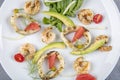 Seafood platter with deep fried squid rings, shrimp decorated with lemon on fresh arugula. Mediterranean appetizers. Top view Royalty Free Stock Photo