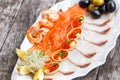 Seafood platter with salmon slice, pangasius fish, red caviar, shrimp, decorated with olives and lemon on wooden background close Royalty Free Stock Photo