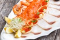 Seafood platter with salmon slice, pangasius fish, red caviar, shrimp, decorated with olives and lemon on wooden background close Royalty Free Stock Photo