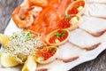 Seafood platter with salmon slice, pangasius fish, red caviar, shrimp, decorated with olives and lemon on wooden background Royalty Free Stock Photo