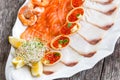 Seafood platter with salmon slice, pangasius fish, red caviar, shrimp, decorated with olives and lemon on wooden background Royalty Free Stock Photo