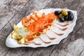Seafood platter with salmon slice, pangasius fish, red caviar, shrimp, decorated with olives and lemon on wooden background Royalty Free Stock Photo