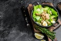 Seafood salad with grilled shrimps prawns, egg, avocado and cucumber in a pan. Dark wooden background. top view. Copy space Royalty Free Stock Photo