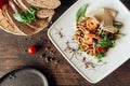 Seafood salad with shrimps and squid in composition with bread at dark wood background